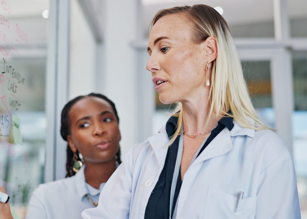 Doctors, planning and women writing on glass mindmap for brainstorming, agenda or hospital schedule. Medicine, science and ideas for innovation with medical team problem solving together at moodboard.